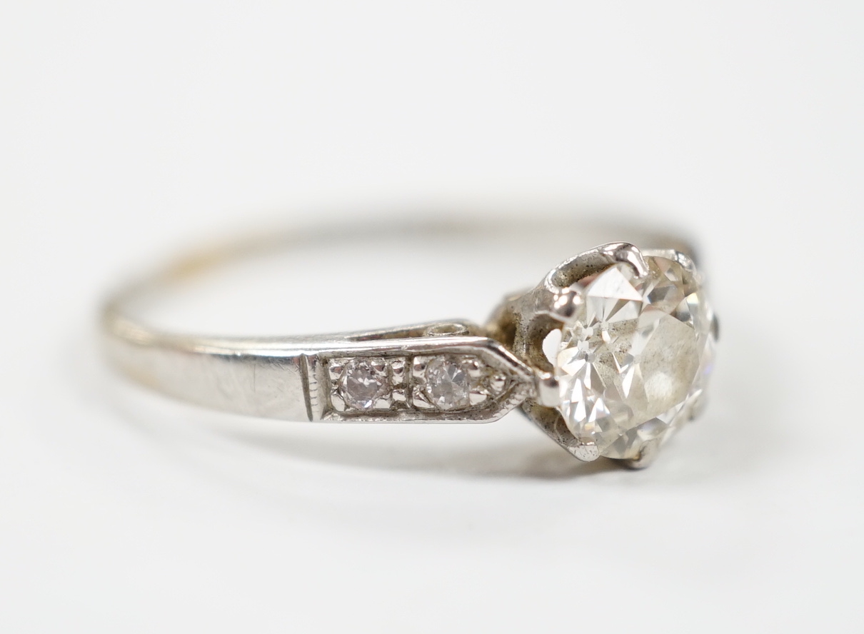 A white metal (stamped plat) and single stone diamond ring with diamond set shoulders, size M/N, gross weight 2.6 grams.